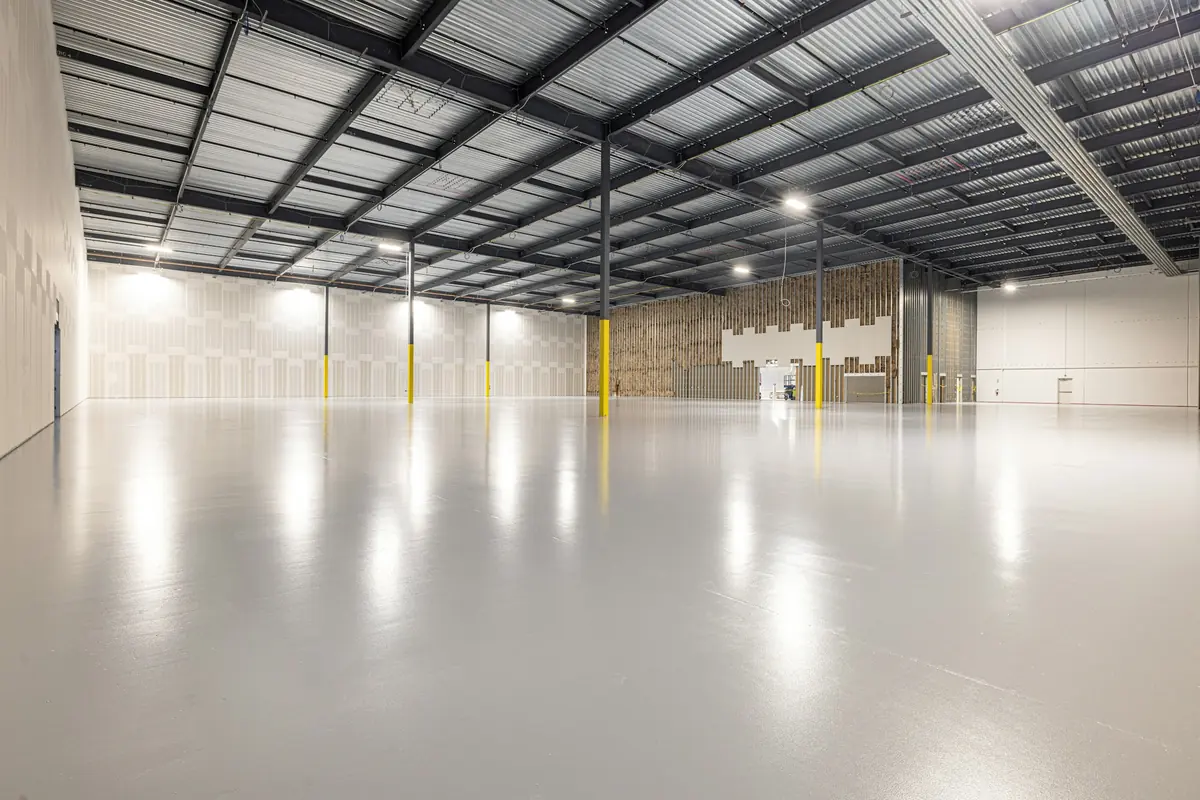 Nave industrial amplia y vacía con suelo de hormigón pulido