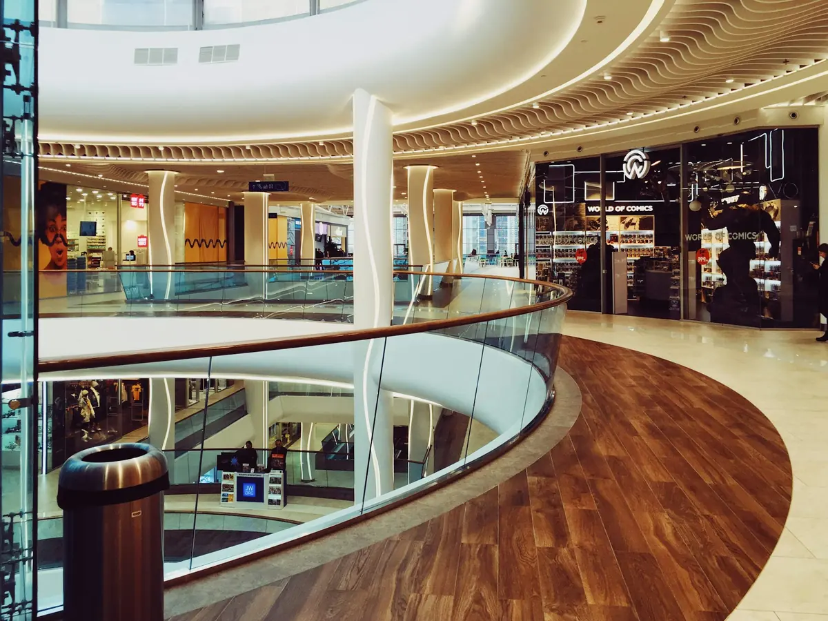 Galería interior de un centro comercial con suelo de madera