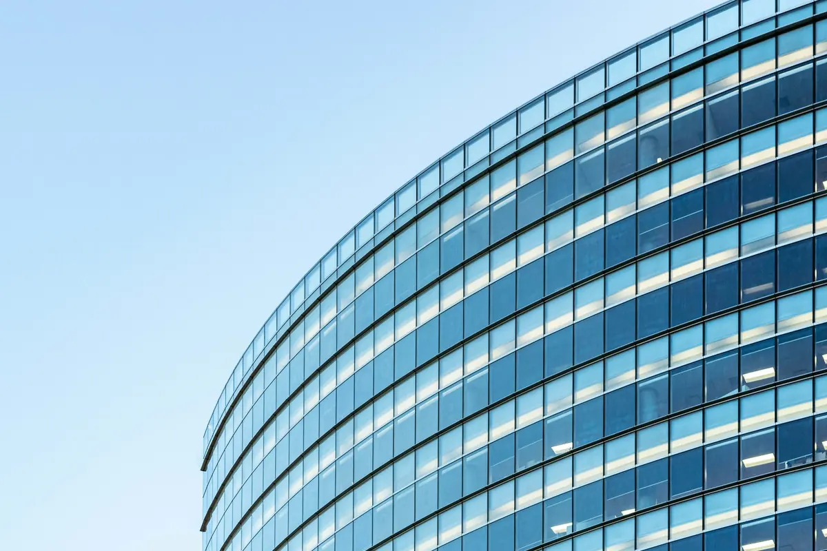 Edificio corporativo moderno con fachada de vidrio blanca y azul