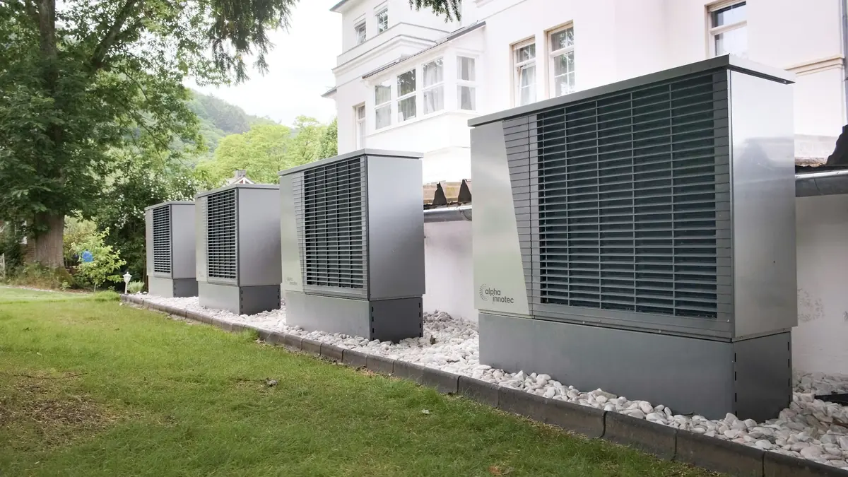Cuatro unidades exteriores de bomba de calor alineadas junto a un edificio