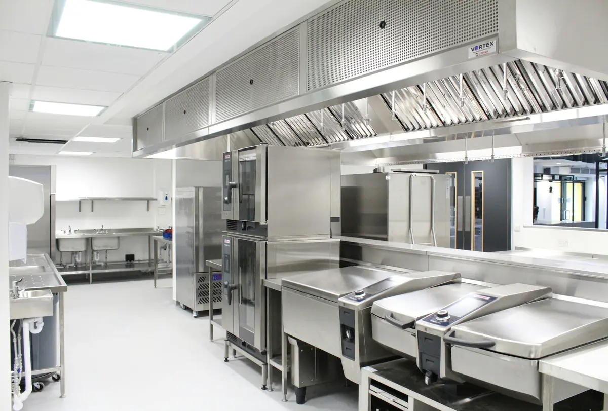 Cocina profesional vacía de acero inoxidable con campana de extracción