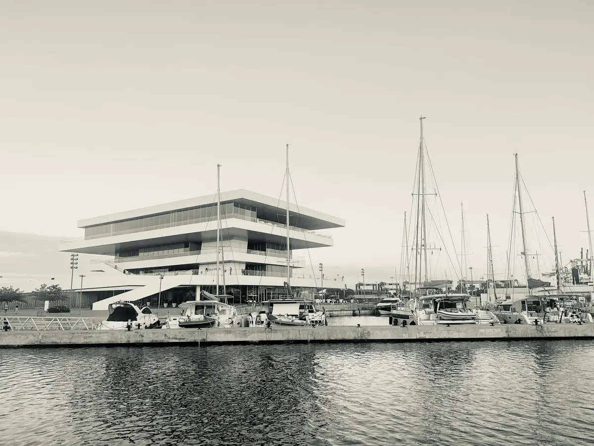 Edificio moderno junto a veleros amarrados en la Marina de Valencia